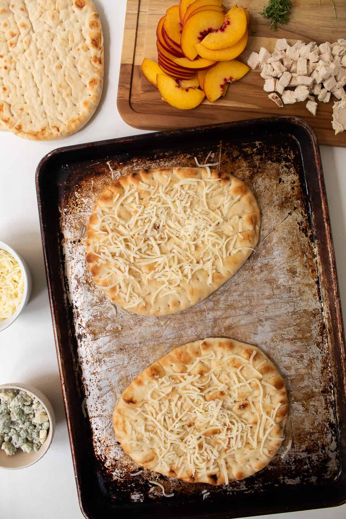 The pizzas are built on a thin layer of mozzarella.