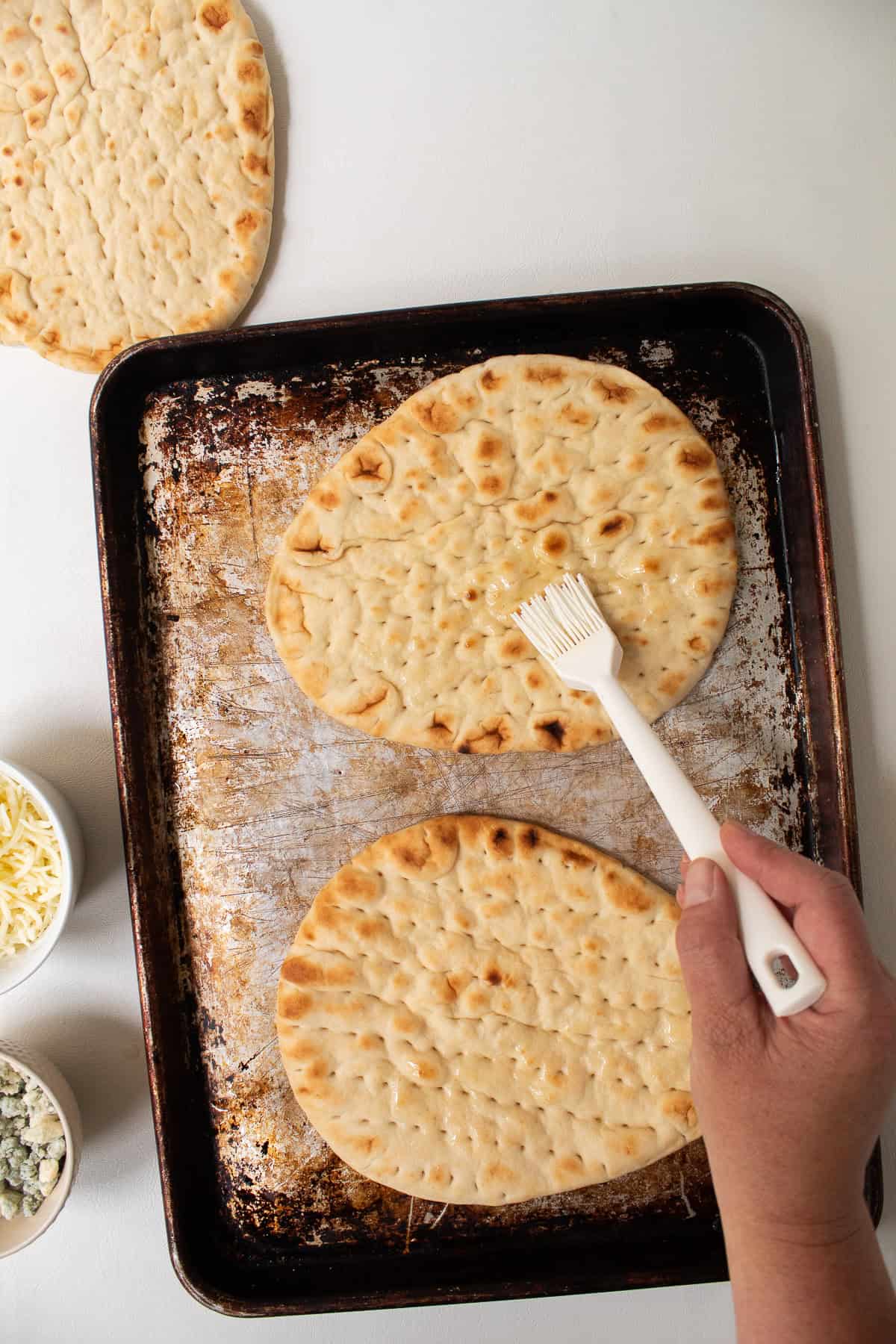The top of the flatbreads are brushed with oil.