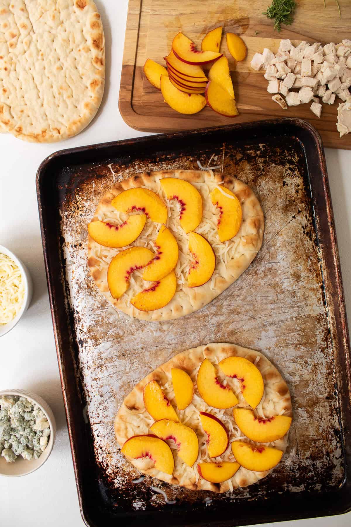 Nectarine slices are added to the pizza.