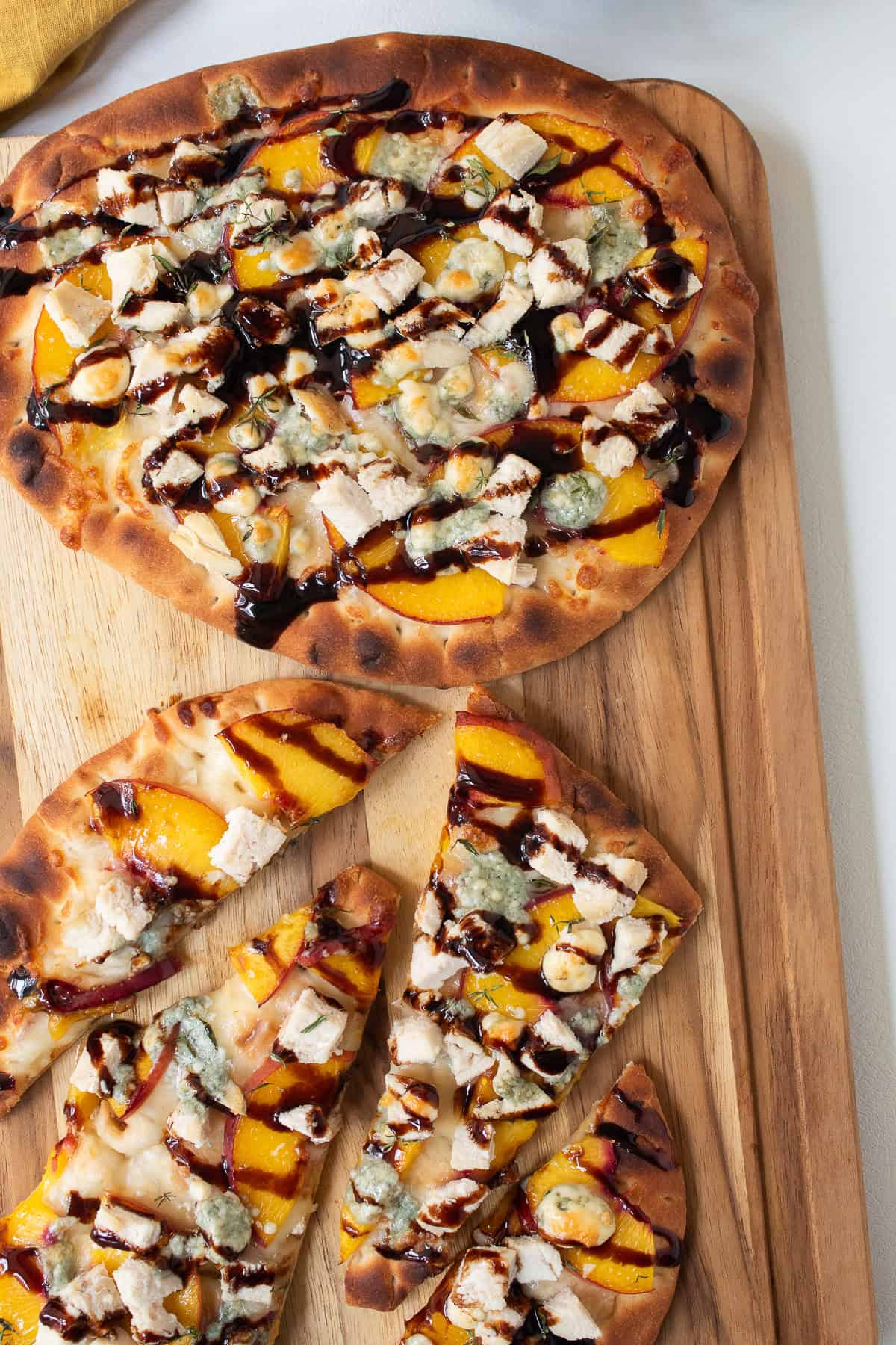 The finished pizza has a golden crust and a hearty drizzle of sweet and sour balsamic glaze.