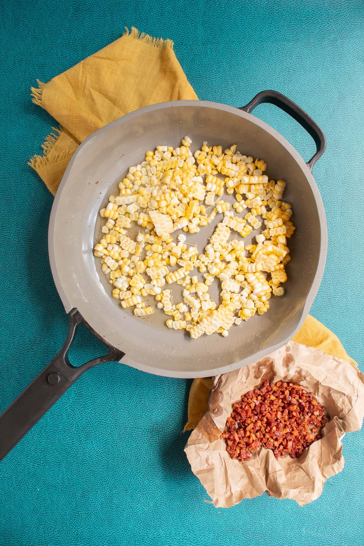 The fresh corn is added to the skillet with the fat rendered from the pancetta.