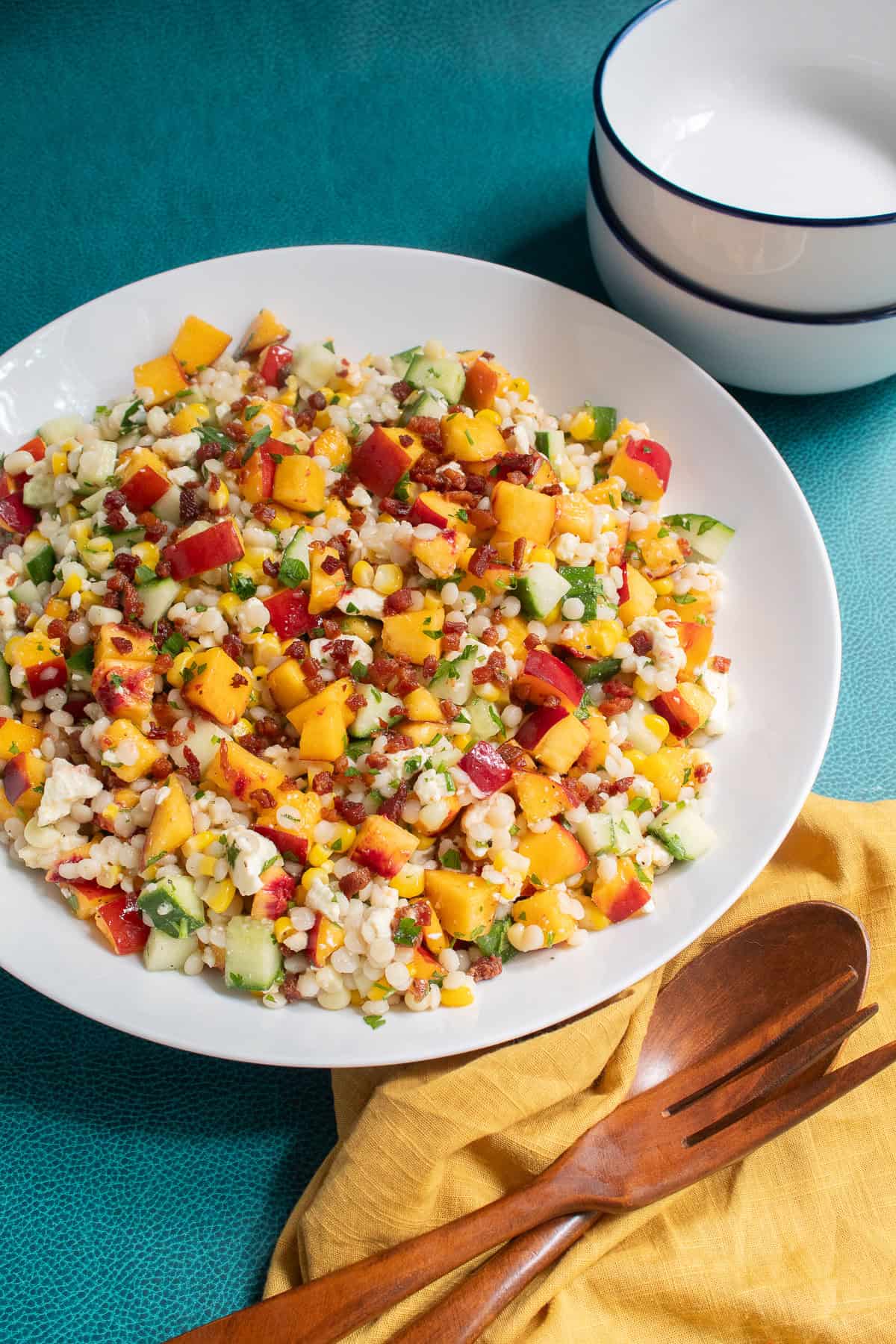 The salad is in a white platter next to blue and white bowls.
