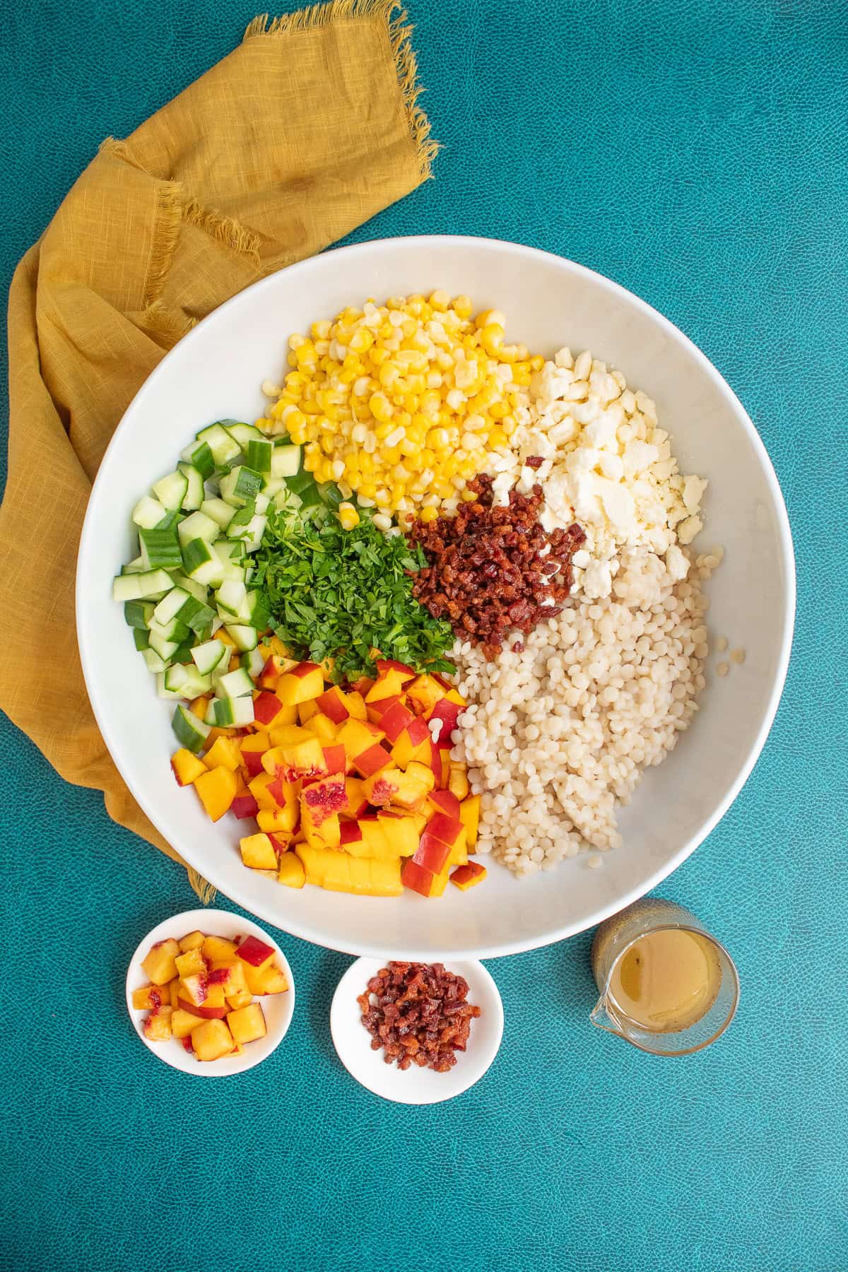 The prepared salad components are added to a large bowl with additional nectarine pieces and pancetta set aside for topping.