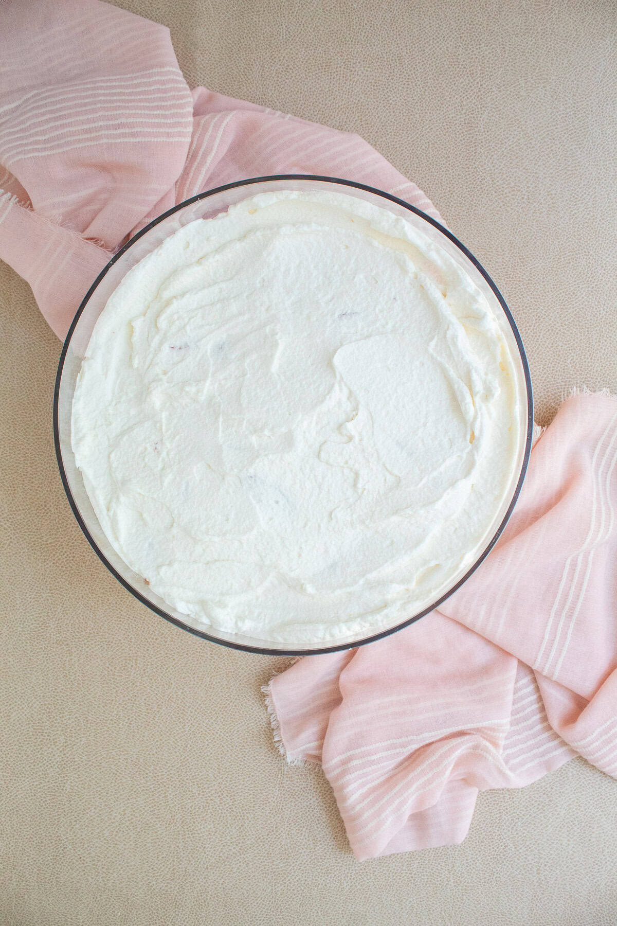 A final layer of whipped cream is added to the trifle.