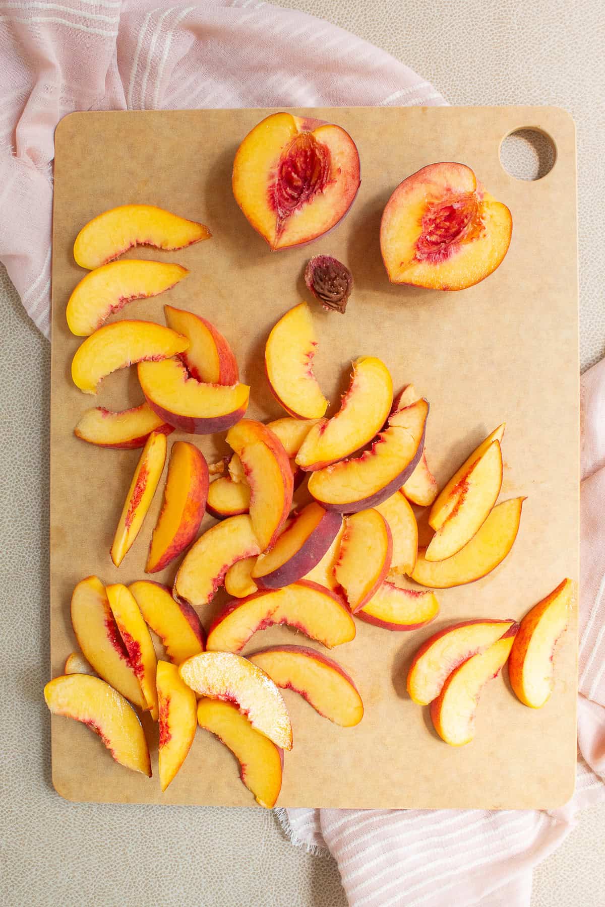 Peaches are halved and sliced into thin wedges.