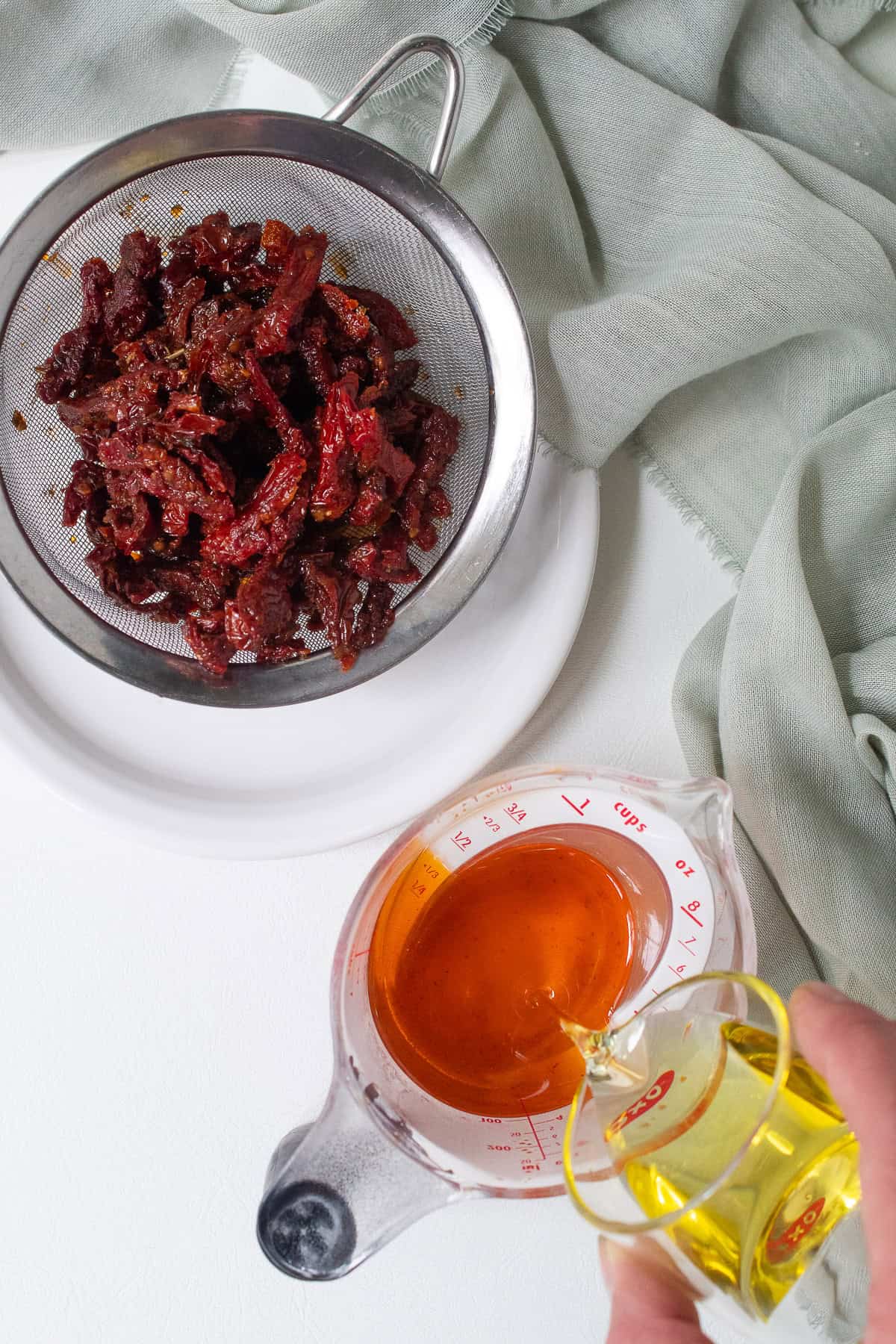 Olive oil is added to the oil drained from the sun dried tomatoes to make ½ cup total oil for the pesto.