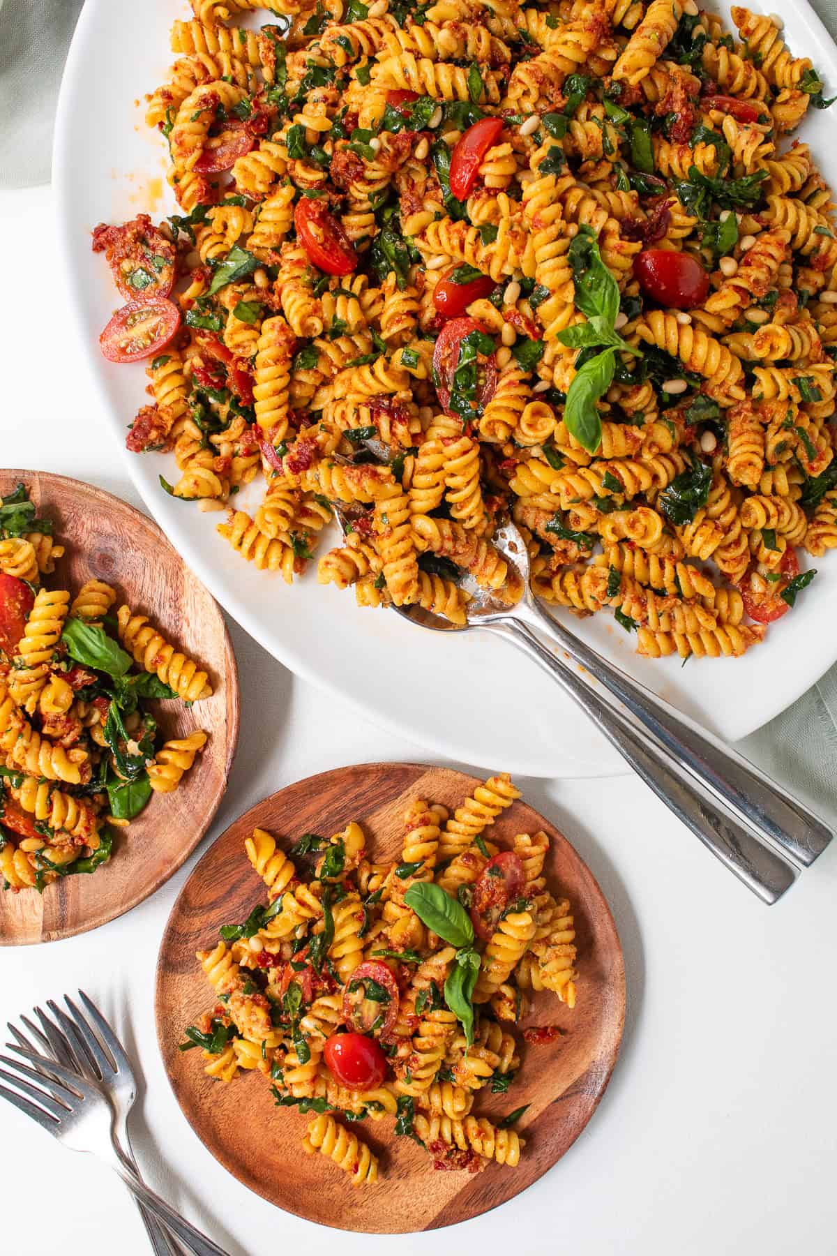 Fusilli pasta is served on wooden plates.