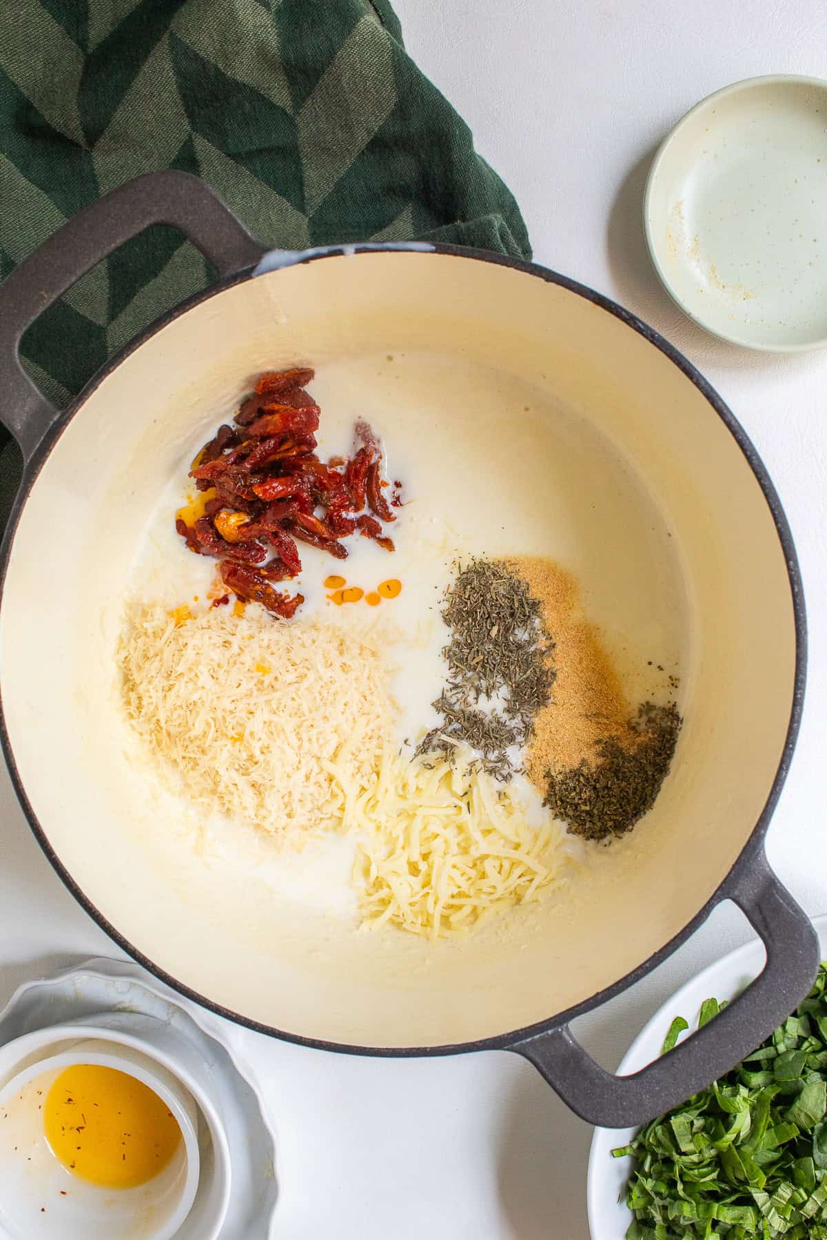 Two cheeses, red strips of dried tomato, and herbs are added to the bechamel.