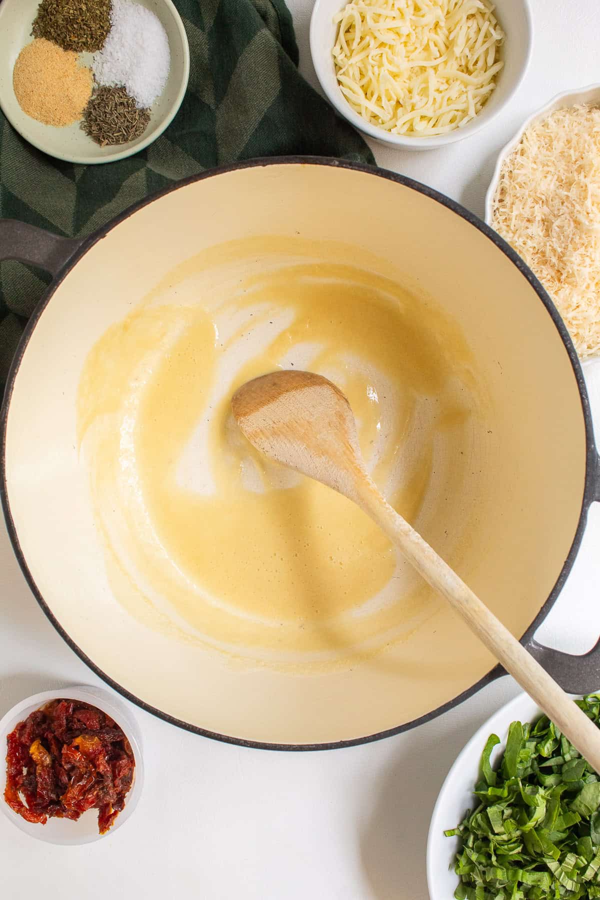 The flour and butter have cooked into a pale blonde roux in the pot.