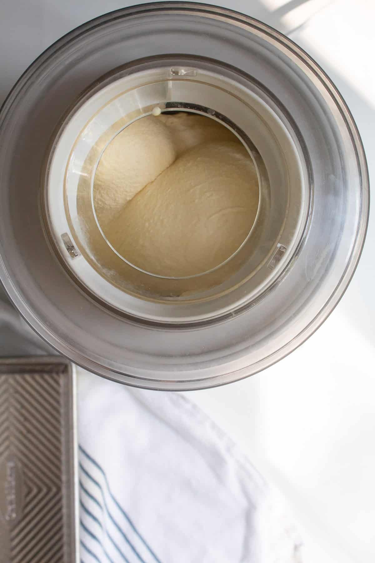 The ice cream is churned to a soft serve consistency in an ice cream maker.
