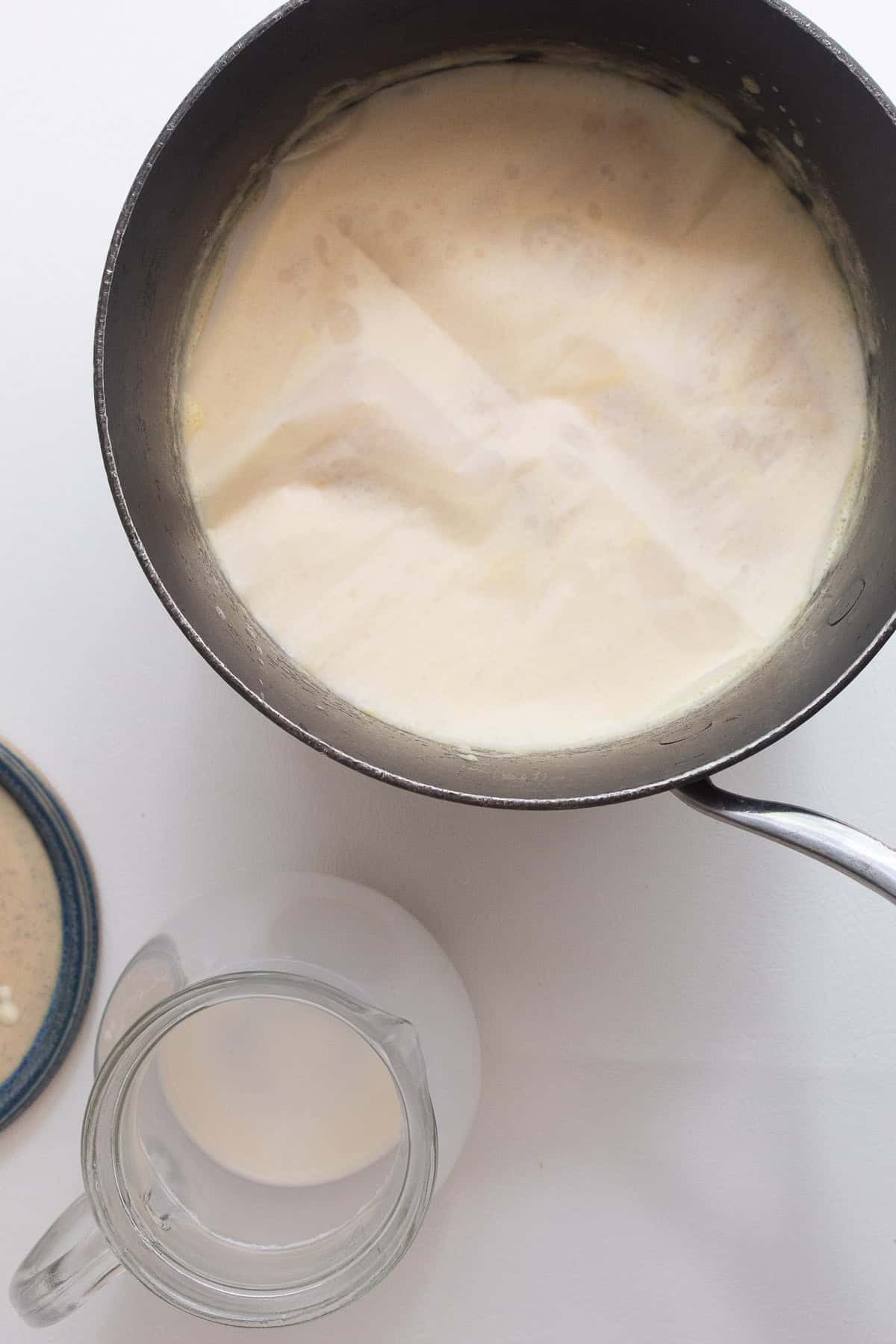 The cream and corn steep together under a circle of parchment.
