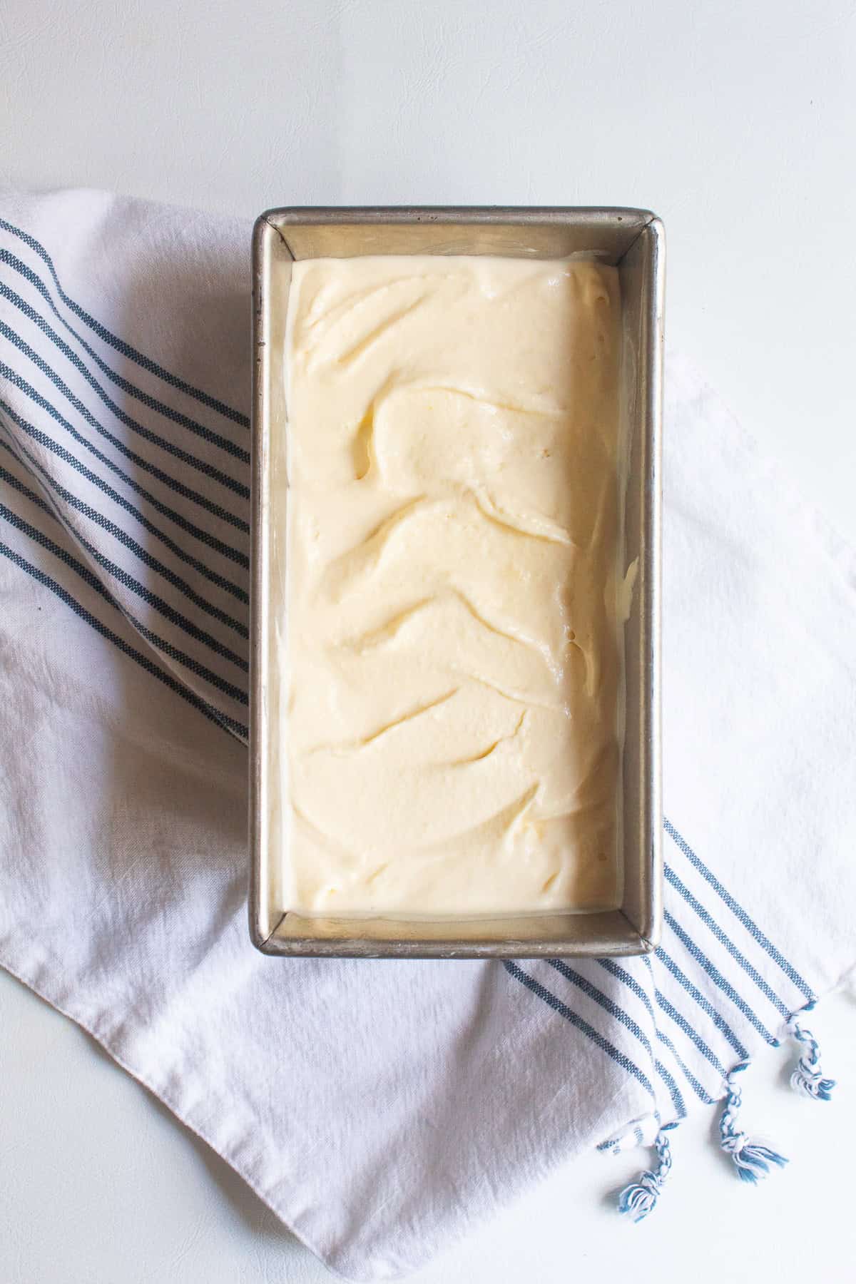 The soft ice cream is transferred into a loaf pan for freezing.