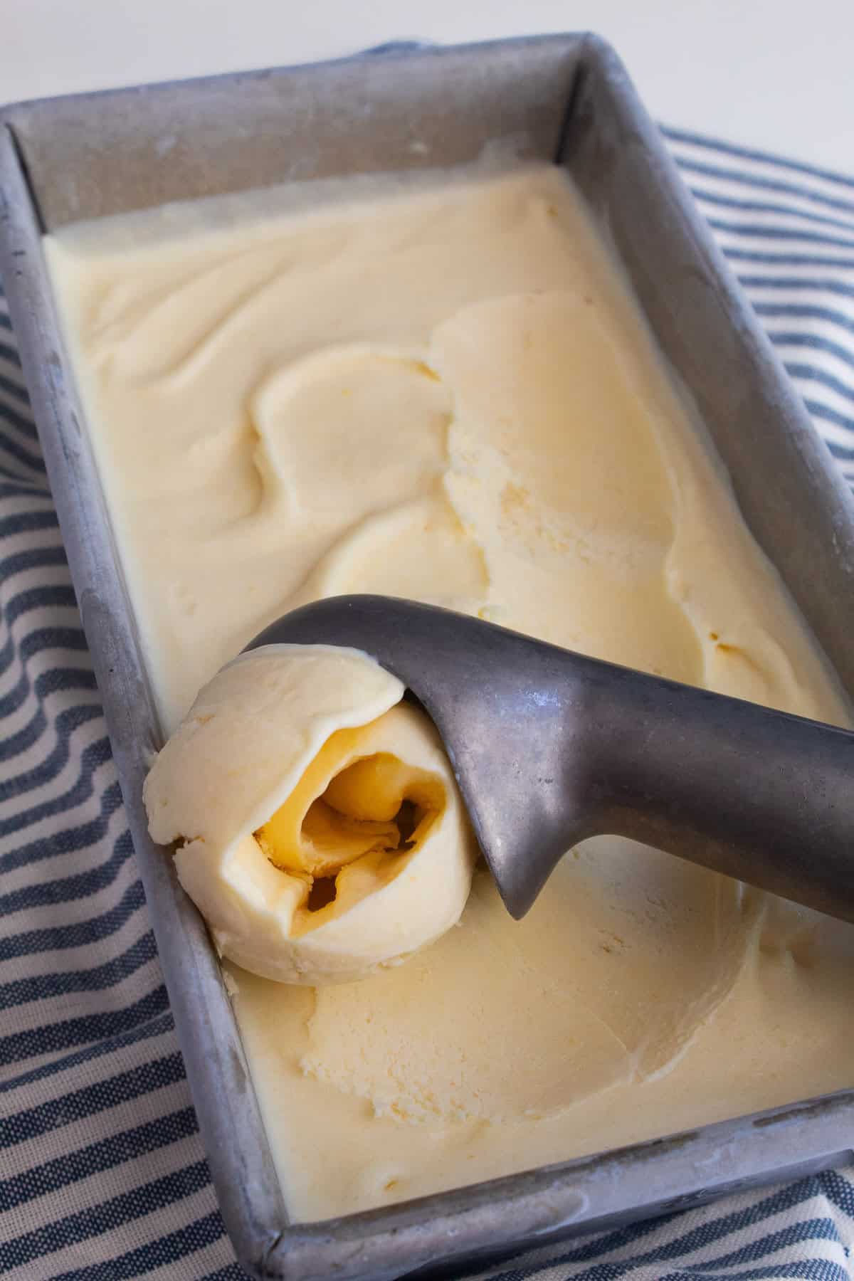 Corn ice cream is scooped out of a loaf pan.