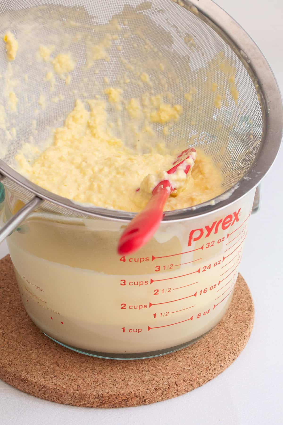 Corn kernels are strained in a mesh strainer.
