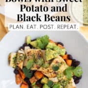 A white bowl is piled high with black beans, roasted sweet potato, mojo marinated chicken, avocado, herbs, and sauce. A white text box at the top of the image contains the words, "mojo chicken bowls with sweet potato and black beans" and " plan. eat. post. repeat."