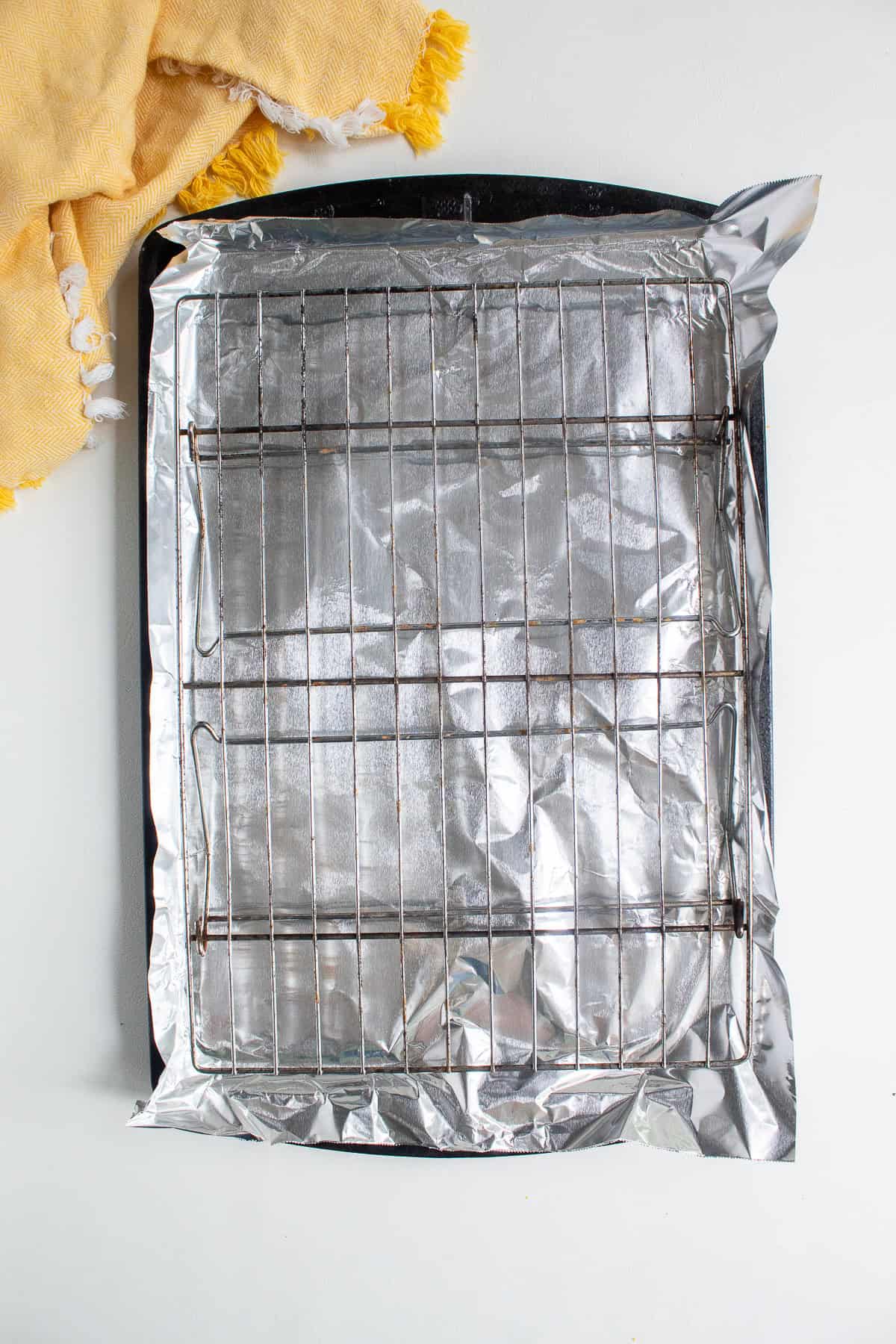 A sheet pan is lined with foil and a wire rack is placed on top for broiling.