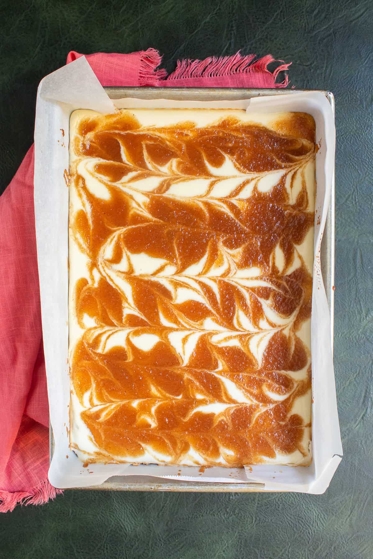 The baked cheesecake bars are lightly golden at the edges. and the filling has set up.