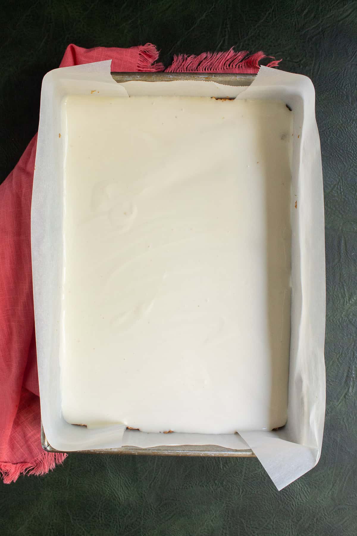 The cheesecake filling is in a smooth layer over the graham cracker crust.