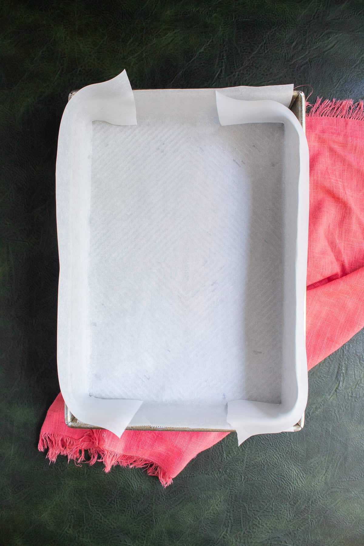 A baking pan is lined with parchment paper.