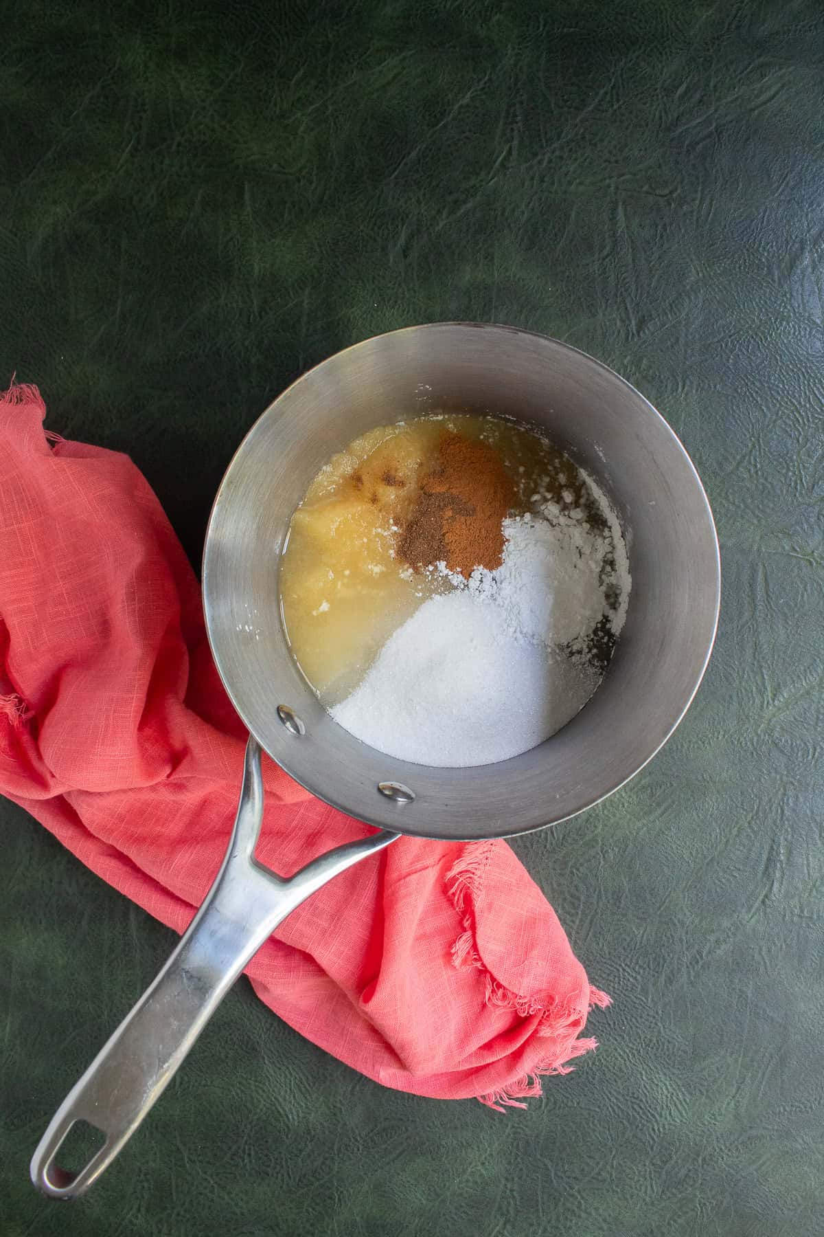 Applesauce, sugar, spices, and cornstarch are added to a medium saucepan.
