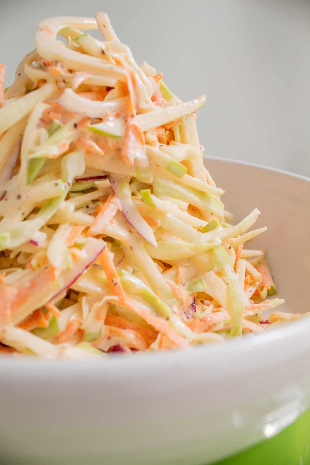 The slaw is piled high with visible red onion, carrot, fennel, and green apple pieces.