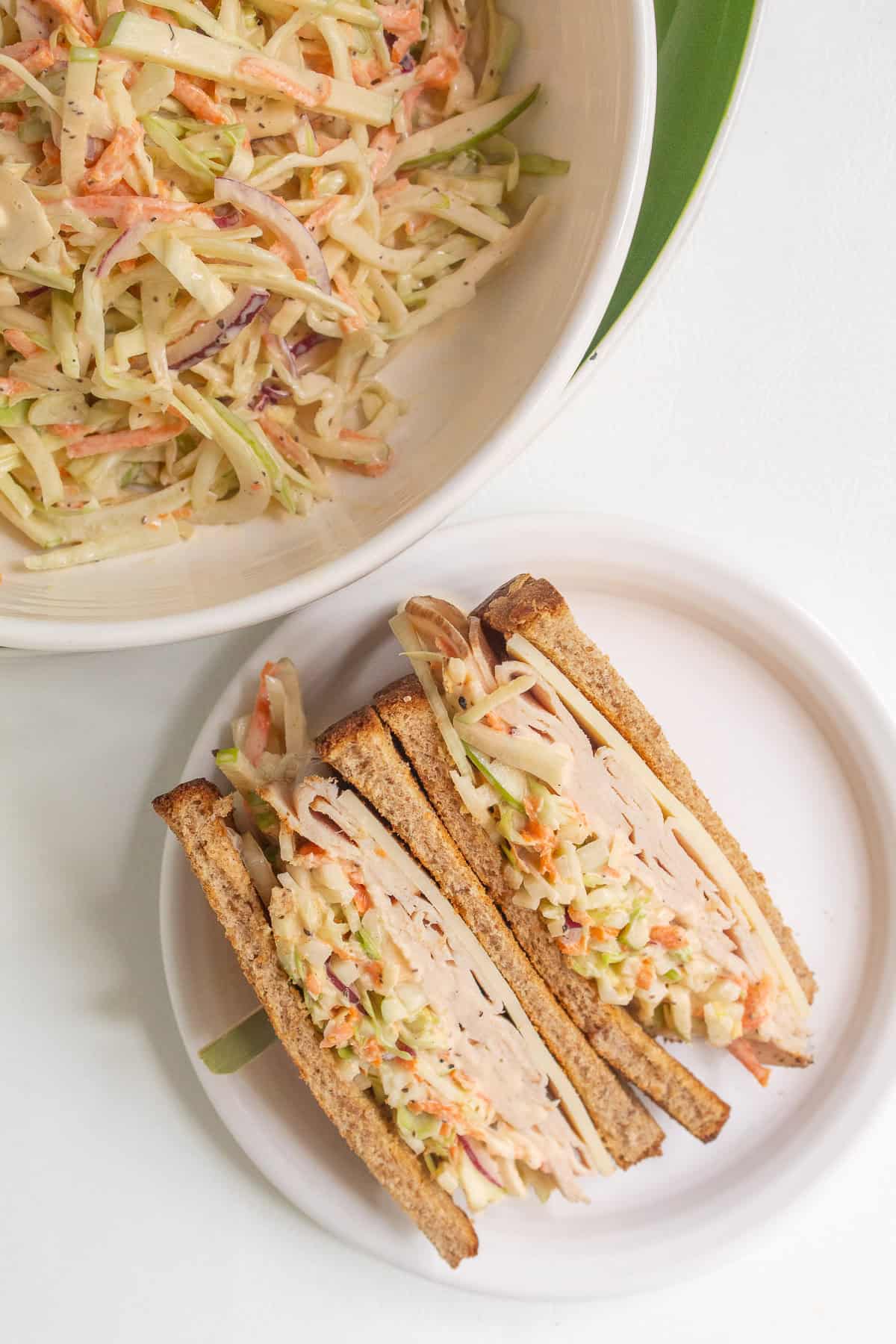 A sandwich is layered with Swiss cheese, turkey, and fennel and apple slaw.