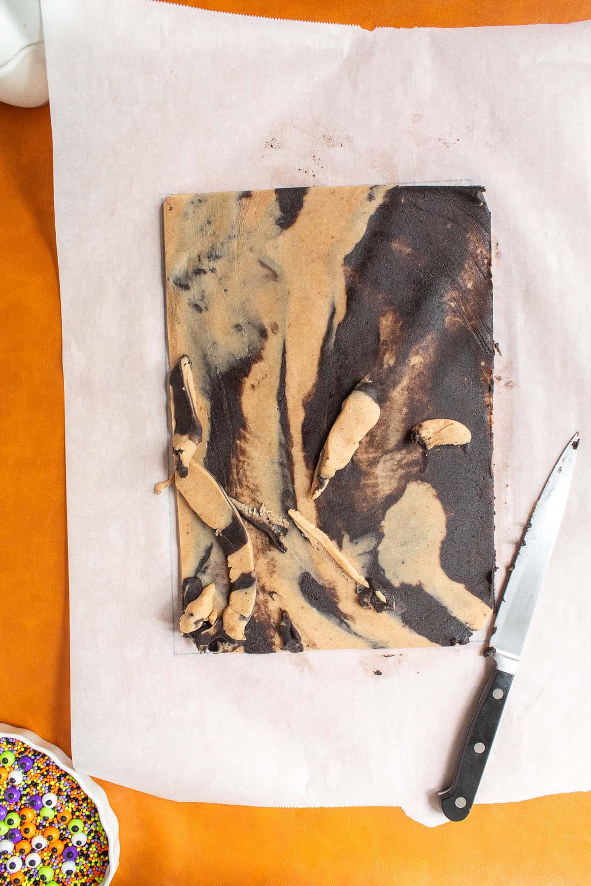 Scraps of dough are trimmed form the edges and placed on top of the sheet of dough.