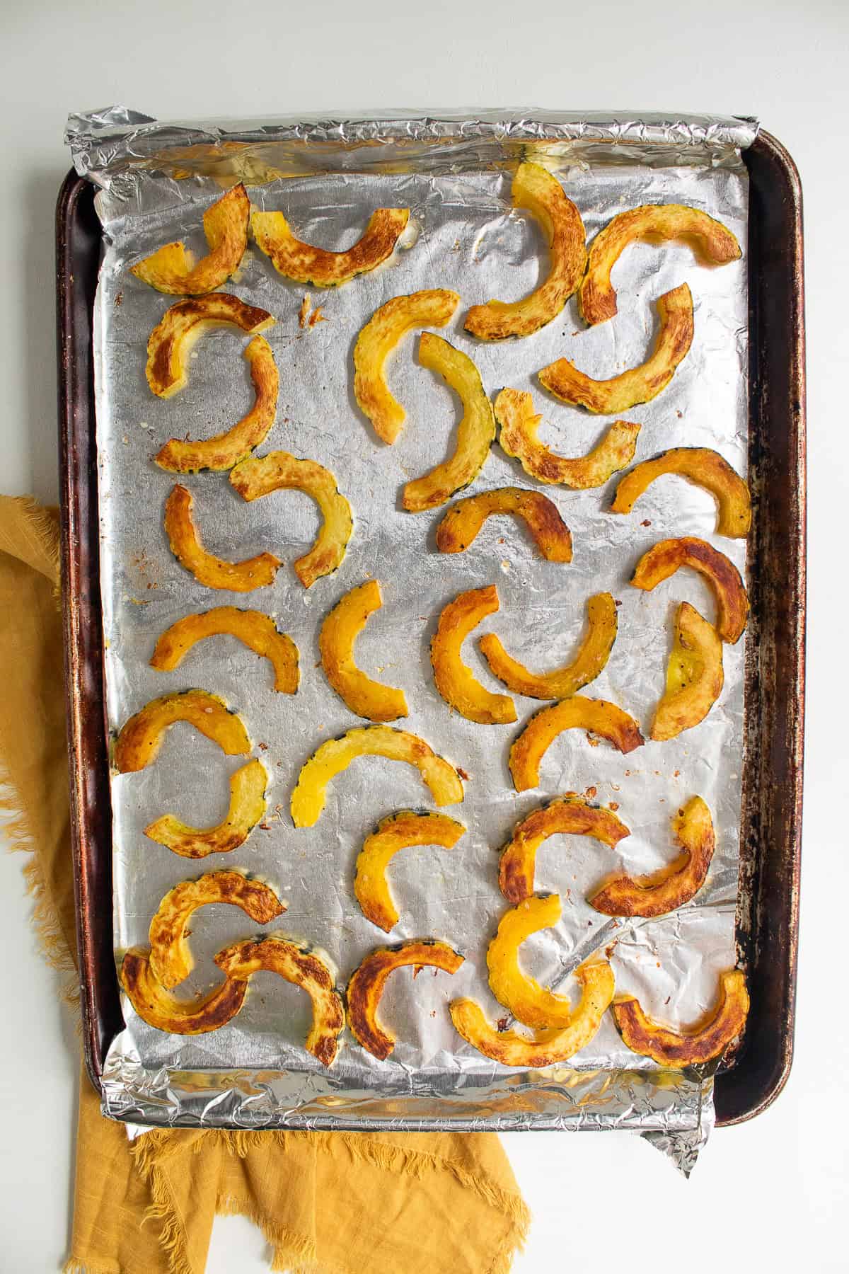Midway through roasting, one side of the squash is caramelized and golden.