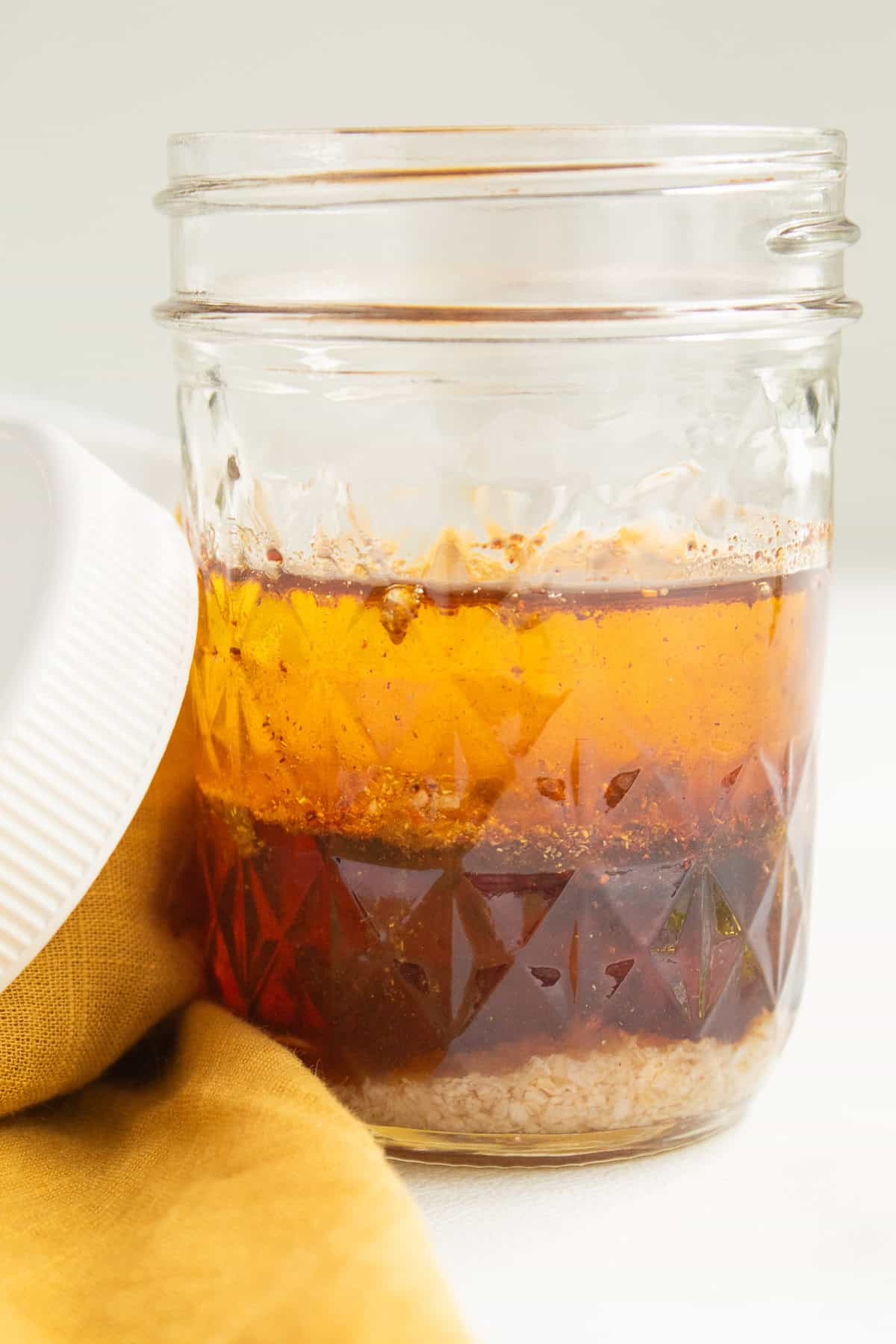 The dressing ingredients are layered in a glass jar.