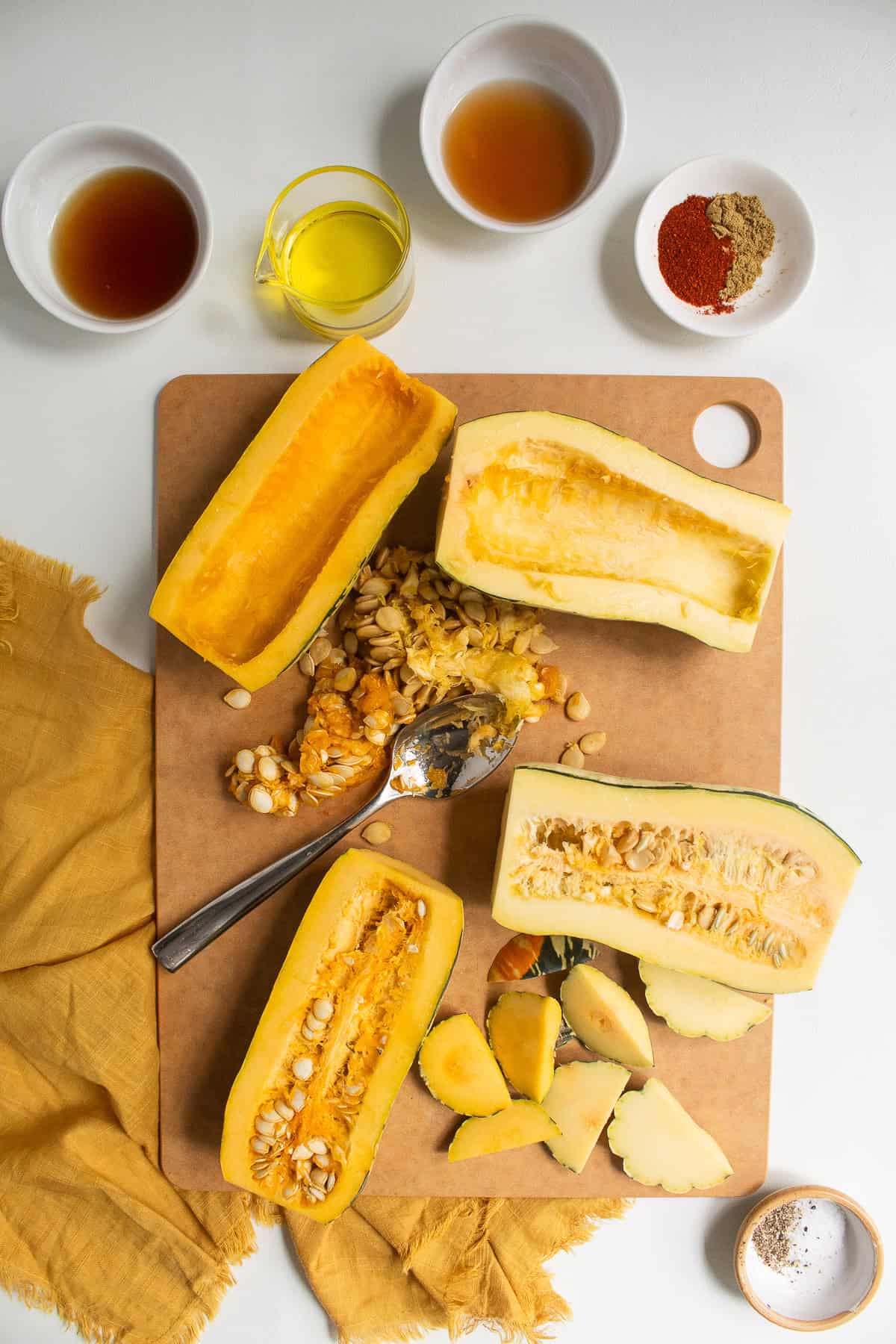 Seeds are removed from the halved squash with a spoon.