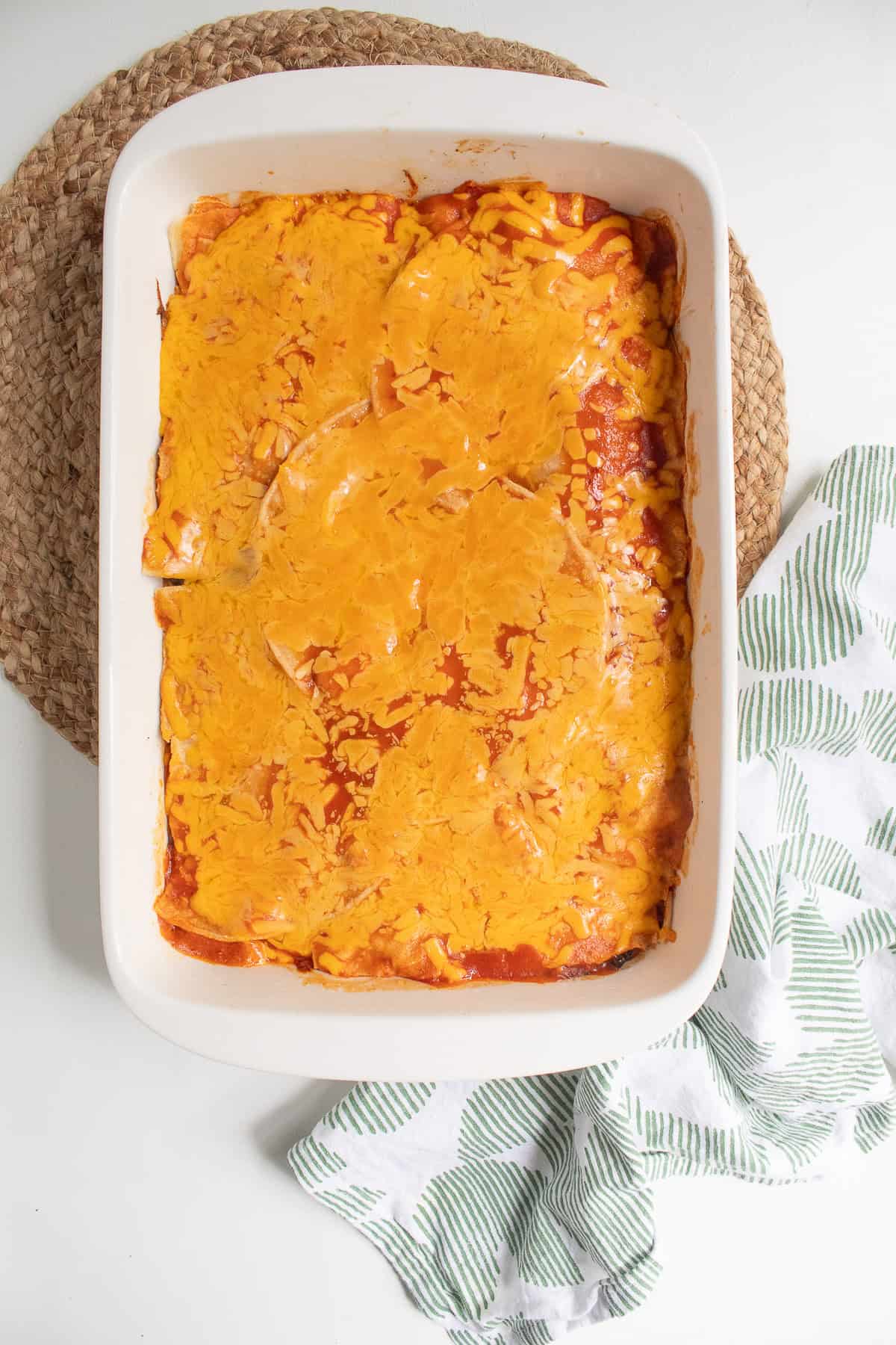 After removing the foil, the enchiladas are partially baked and the cheese on top is melted.