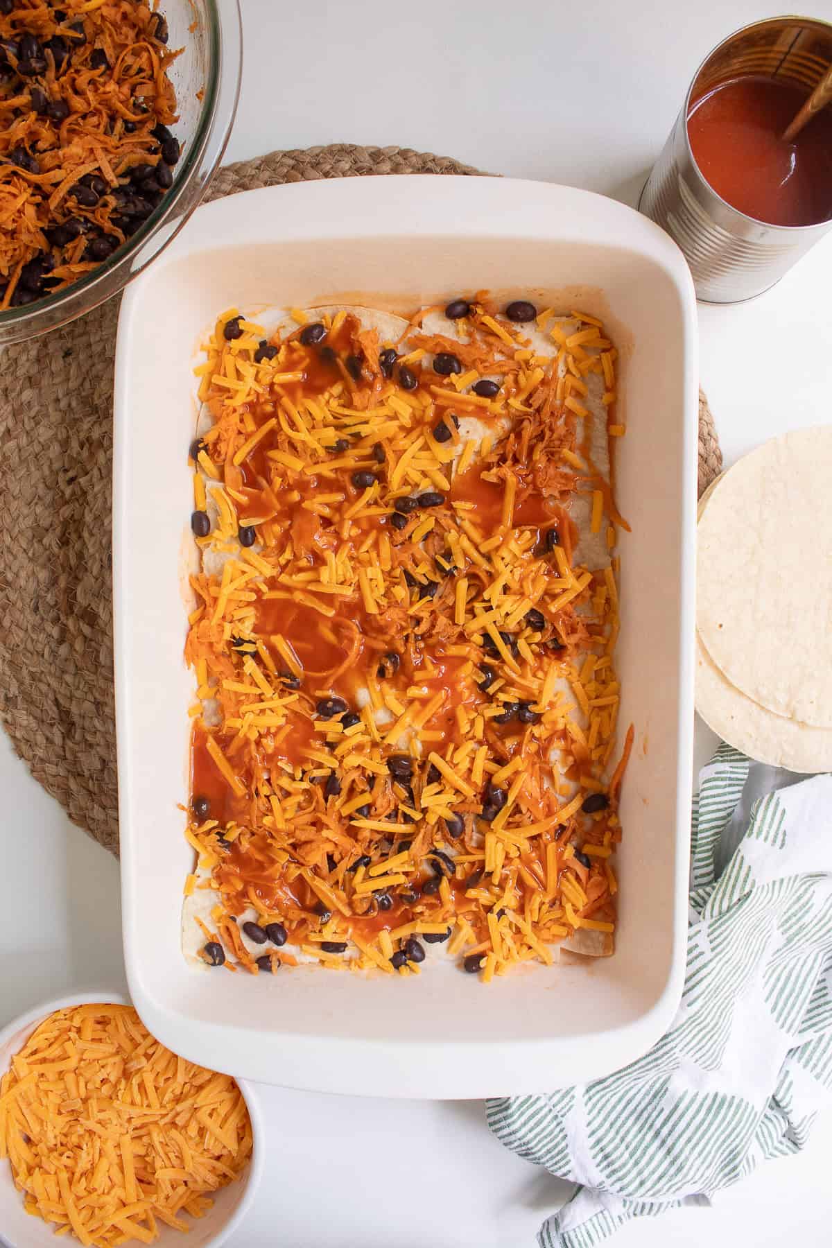 Enchilada sauce is layered on top of the cheese and filling.