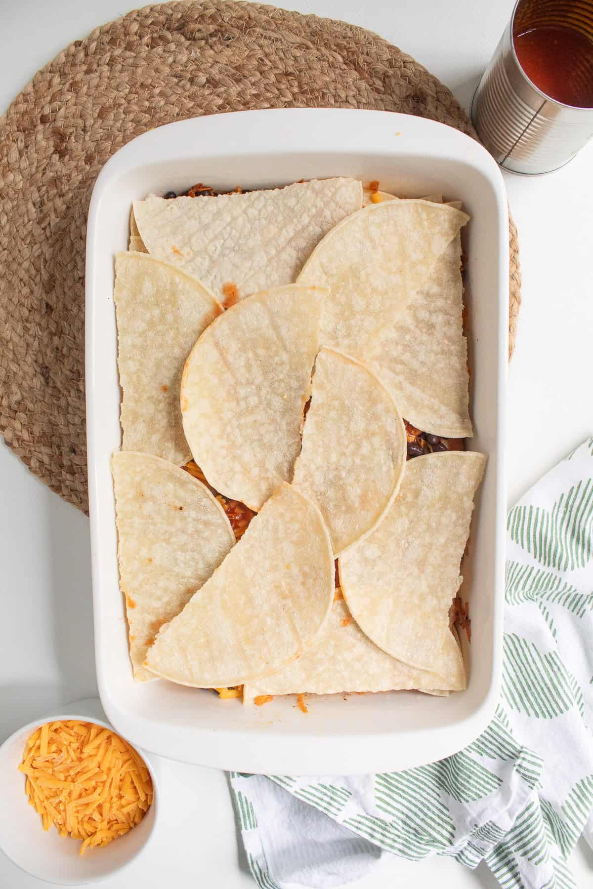 Torn tortillas top the last layer of the sweet potato and black bean filling.