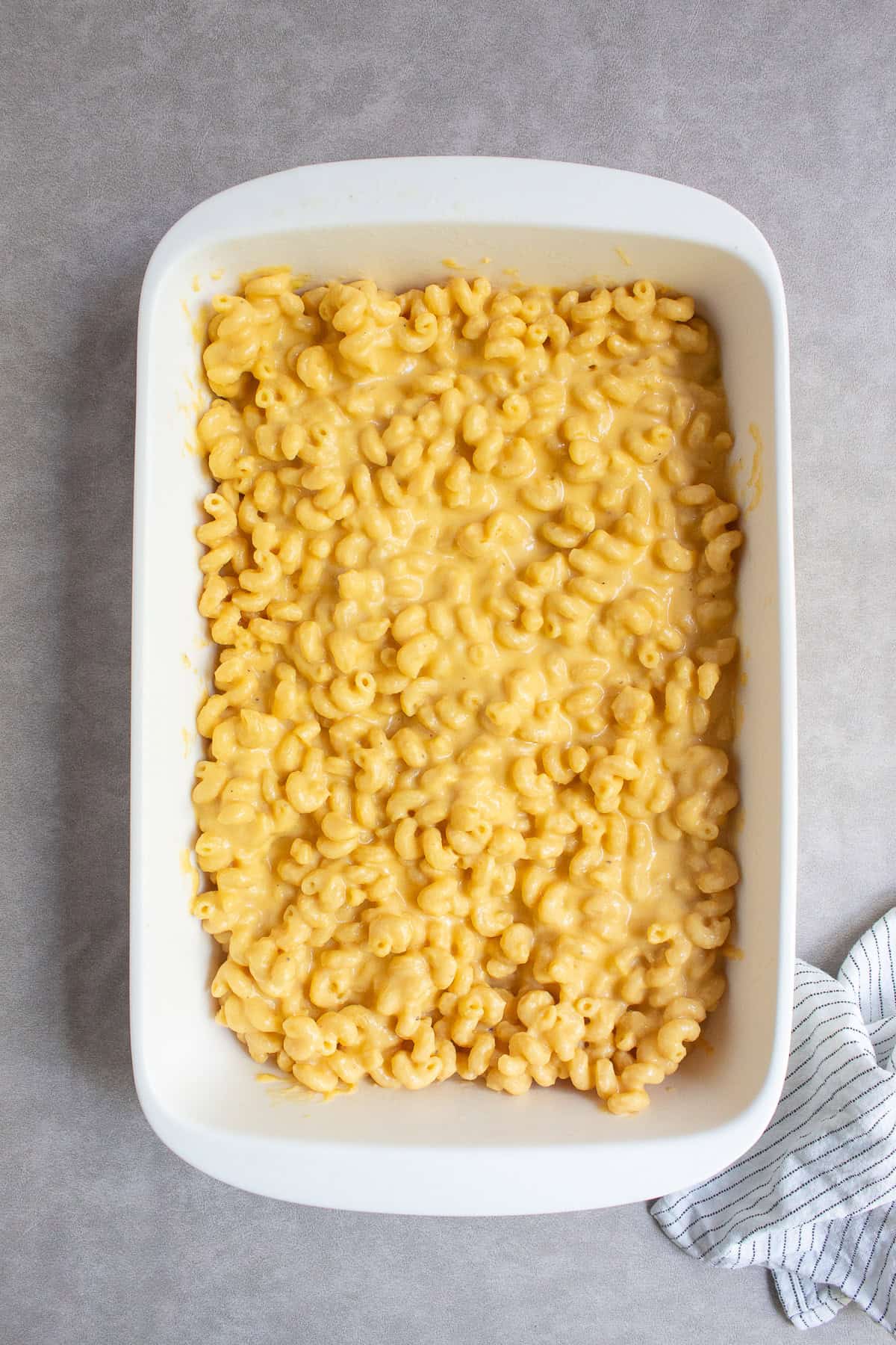 The pasta and sauce mixture are transferred to the greased casserole dish.