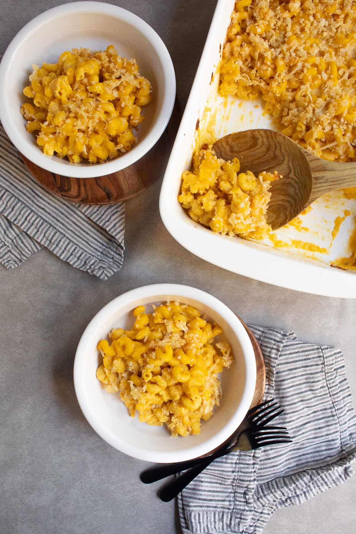 Two white bowls are heaped with the cooked macaroni pasta.