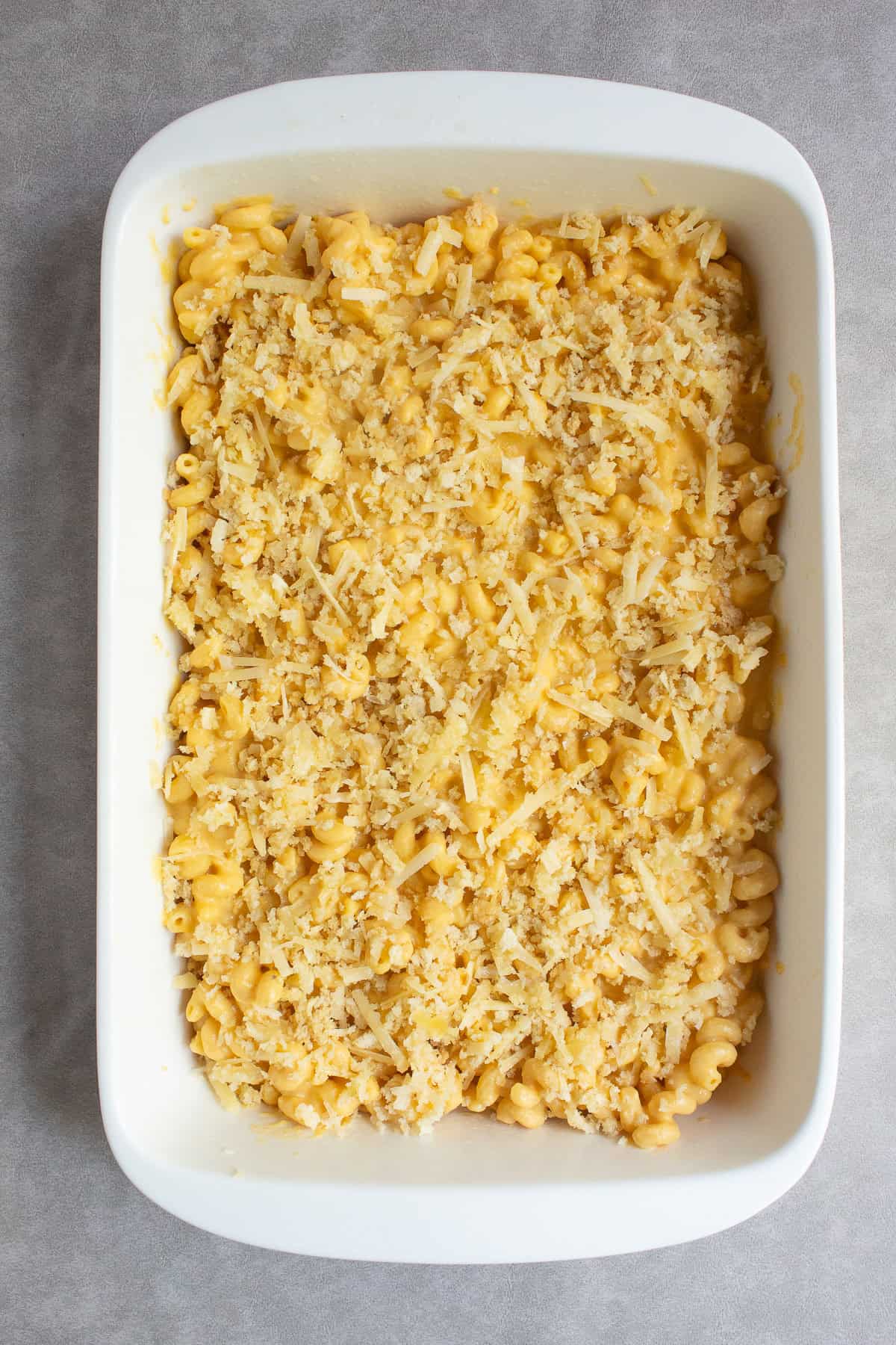 The pasta is topped with the breadcrumb mixture before baking.