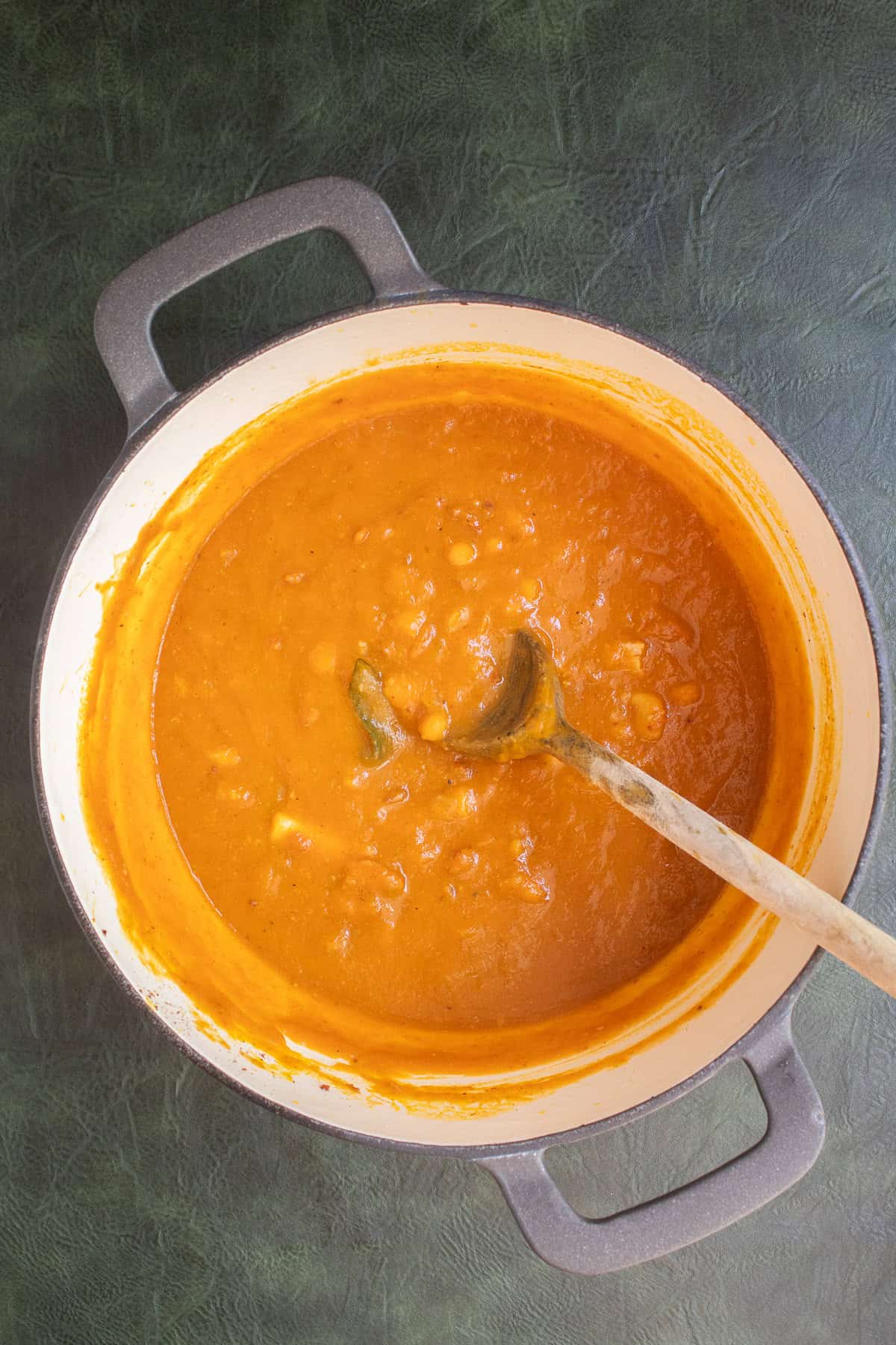 The pumpkin and bean mixture is simmered until thickened.